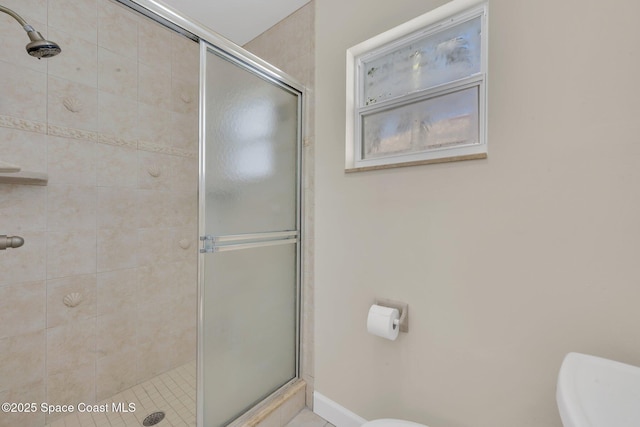 full bathroom featuring toilet and a stall shower