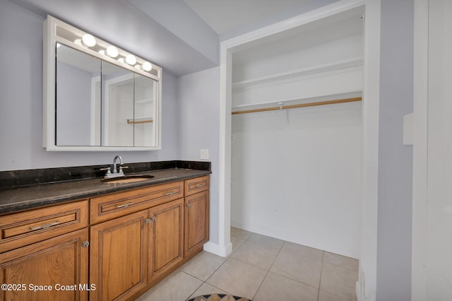 bathroom with baseboards, vanity, and tile patterned flooring