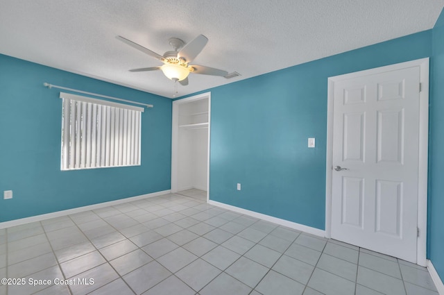 spare room with baseboards, visible vents, a textured ceiling, and a ceiling fan