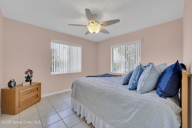 bedroom with light tile patterned flooring, ceiling fan, and baseboards