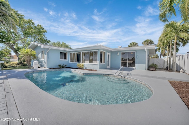 view of pool with a patio area, fence, a fenced in pool, and a sunroom