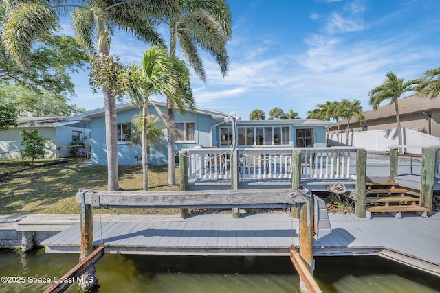 view of dock featuring fence, a yard, and a water view