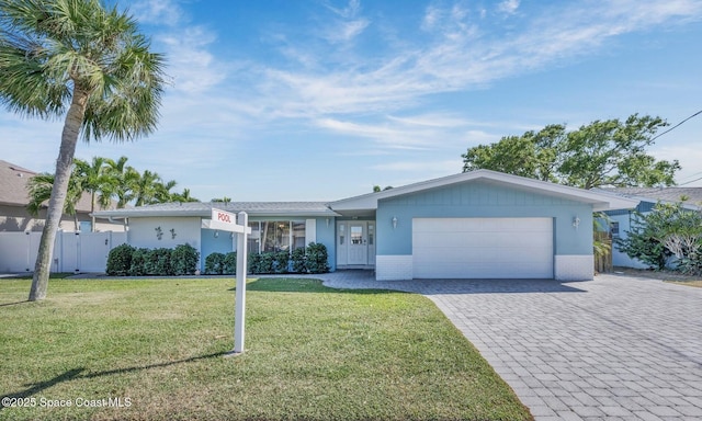 single story home featuring fence, a front yard, stucco siding, decorative driveway, and an attached garage