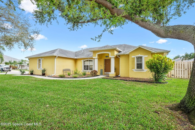 view of front facade featuring a front yard, fence, and stucco siding