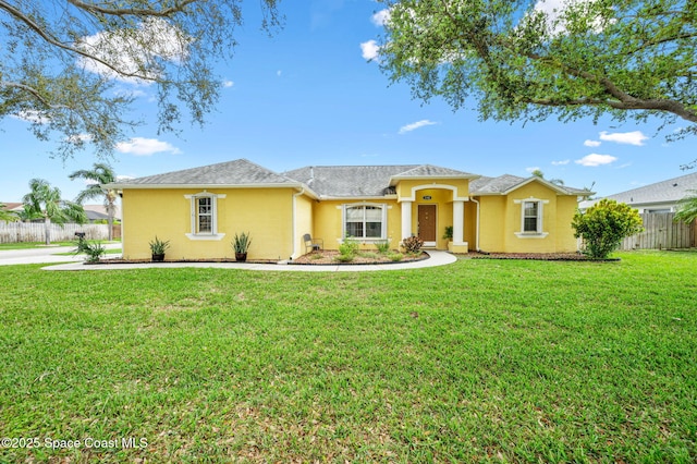 view of front of house with a front yard, fence, and stucco siding