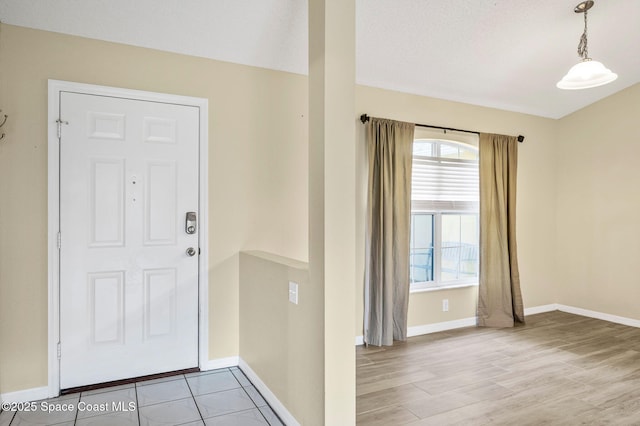 foyer with light wood-type flooring and baseboards