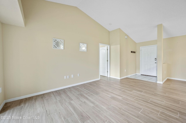 interior space with high vaulted ceiling, wood tiled floor, and baseboards