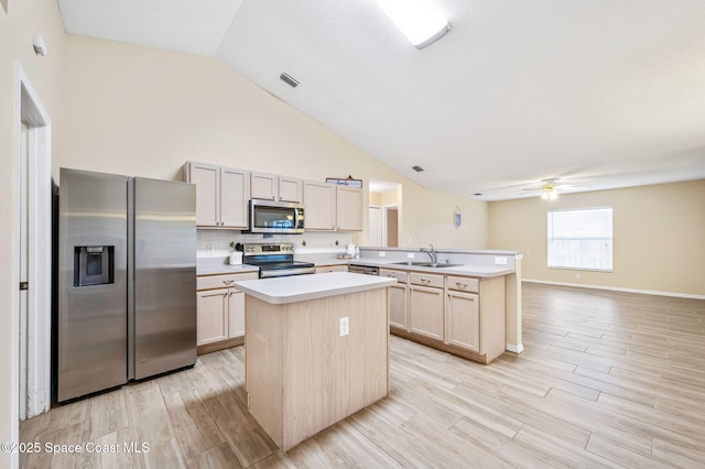 kitchen featuring visible vents, appliances with stainless steel finishes, a peninsula, light countertops, and a sink