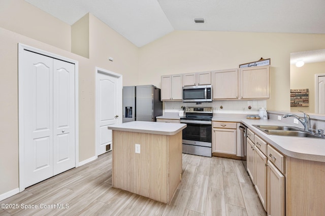 kitchen featuring light brown cabinetry, appliances with stainless steel finishes, a sink, and visible vents