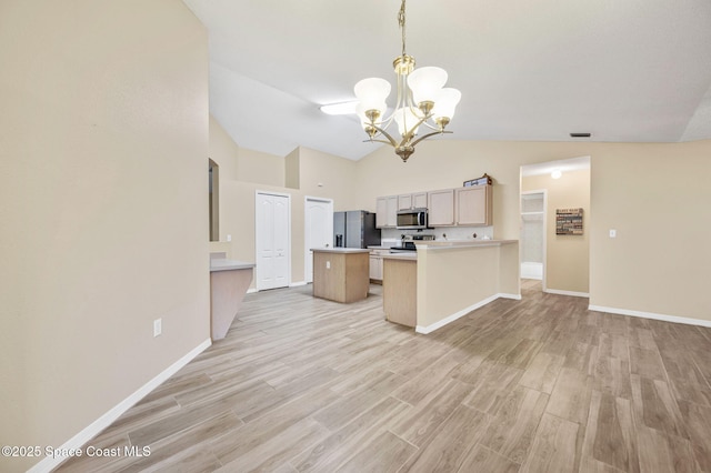 kitchen featuring light countertops, stainless steel microwave, light wood-style flooring, and black fridge