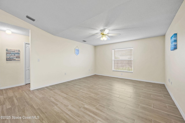 spare room with ceiling fan, a textured ceiling, visible vents, and light wood-style floors