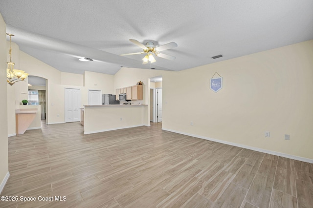 unfurnished living room featuring arched walkways, visible vents, light wood-style floors, vaulted ceiling, and ceiling fan with notable chandelier