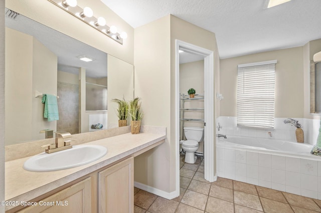 full bath with toilet, vanity, a textured ceiling, tile patterned flooring, and a bath