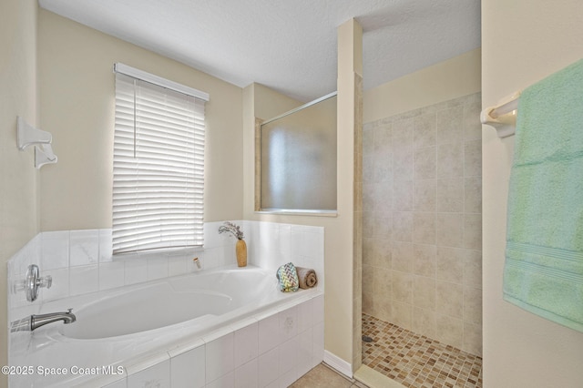 bathroom featuring a garden tub, a textured ceiling, and walk in shower