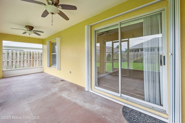 unfurnished sunroom with ceiling fan