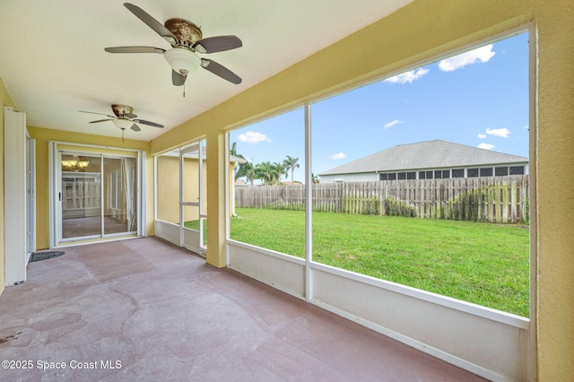 unfurnished sunroom with ceiling fan