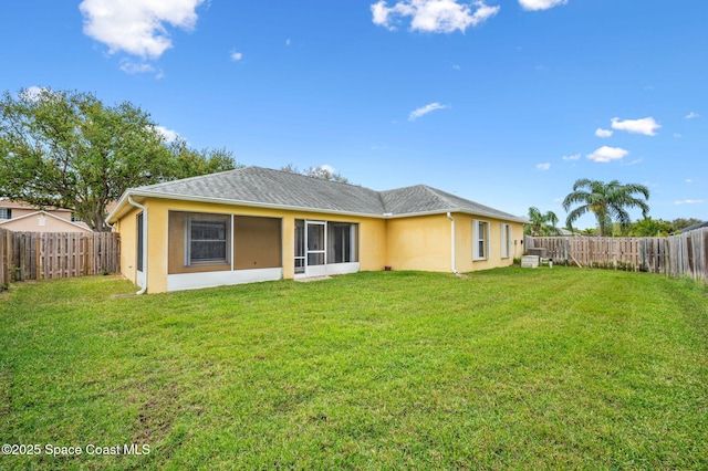 back of property featuring a yard, roof with shingles, a fenced backyard, and stucco siding