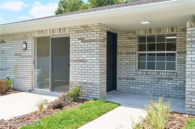 view of exterior entry with brick siding