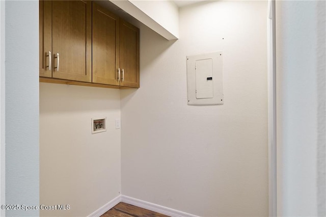 clothes washing area featuring electric panel, cabinet space, baseboards, and washer hookup