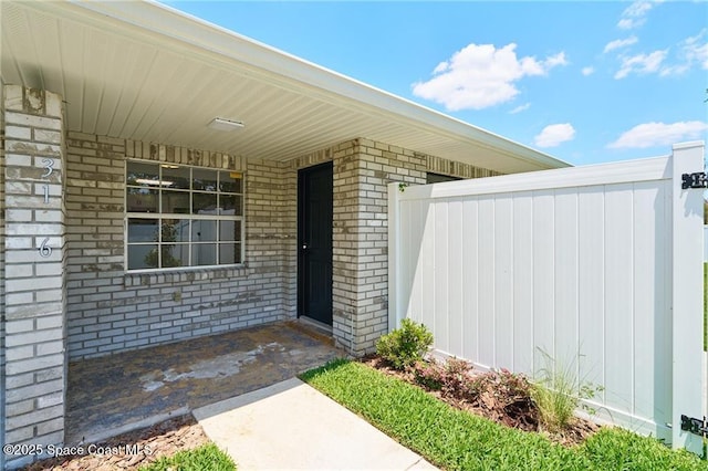 property entrance featuring brick siding