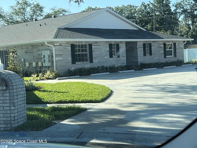 view of front of property featuring brick siding and a shingled roof