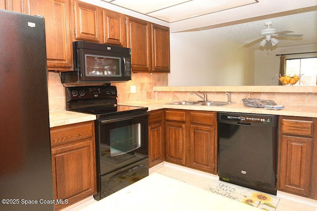 kitchen with tasteful backsplash, light countertops, a sink, and black appliances