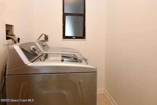 laundry area with laundry area, washer and clothes dryer, light tile patterned flooring, and baseboards