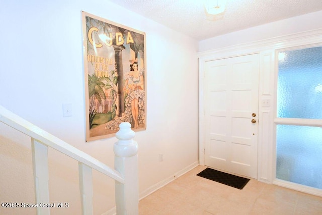 entrance foyer with a textured ceiling and baseboards