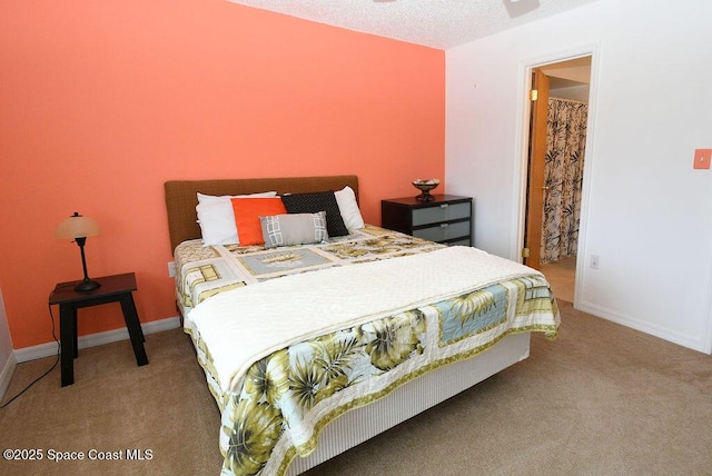 bedroom with a textured ceiling, carpet flooring, and baseboards