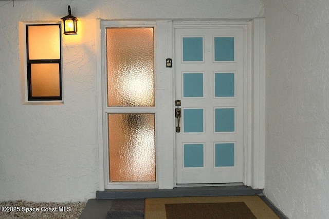 view of exterior entry with stucco siding