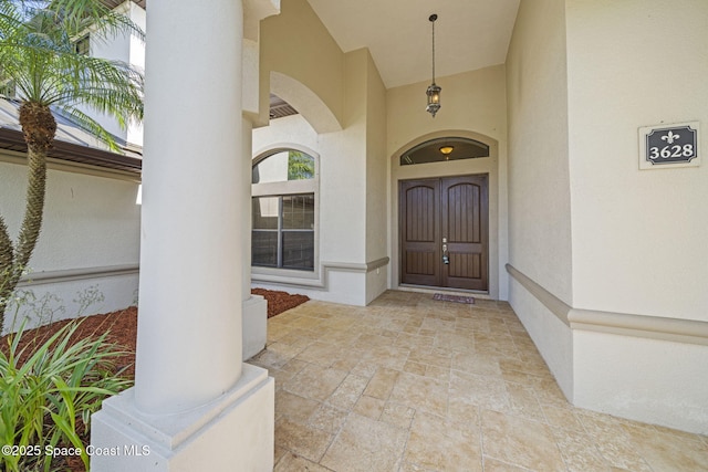 doorway to property featuring stucco siding