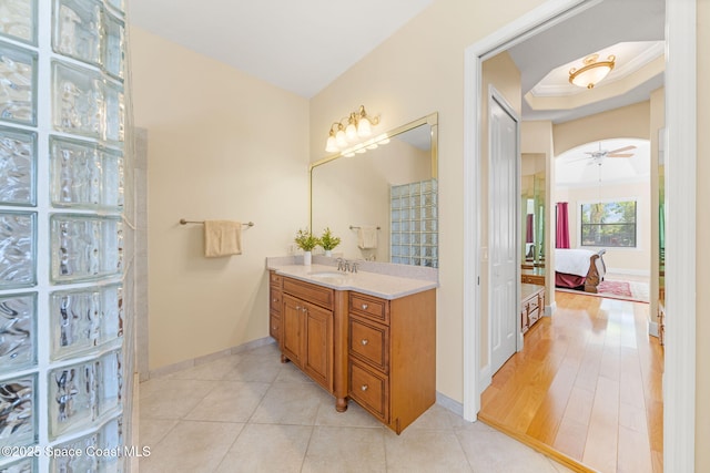 ensuite bathroom with baseboards, connected bathroom, tile patterned floors, and vanity