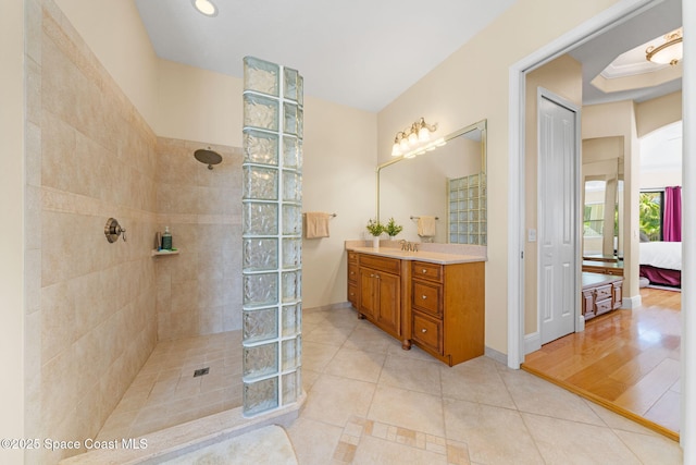ensuite bathroom with ensuite bathroom, tile patterned flooring, and walk in shower