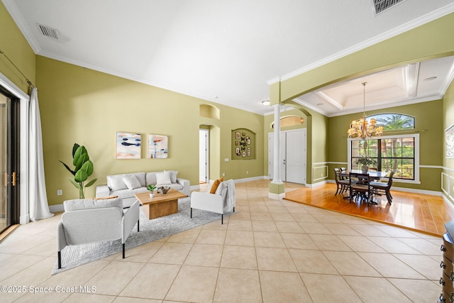 living room featuring visible vents, ornamental molding, arched walkways, an inviting chandelier, and light tile patterned floors