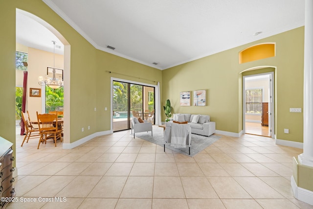 living area featuring light tile patterned flooring, visible vents, crown molding, and arched walkways