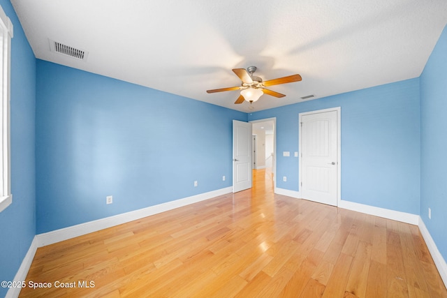 unfurnished bedroom featuring baseboards, light wood-style flooring, and visible vents