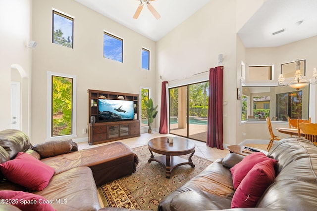 living room featuring light tile patterned floors, high vaulted ceiling, baseboards, visible vents, and a ceiling fan