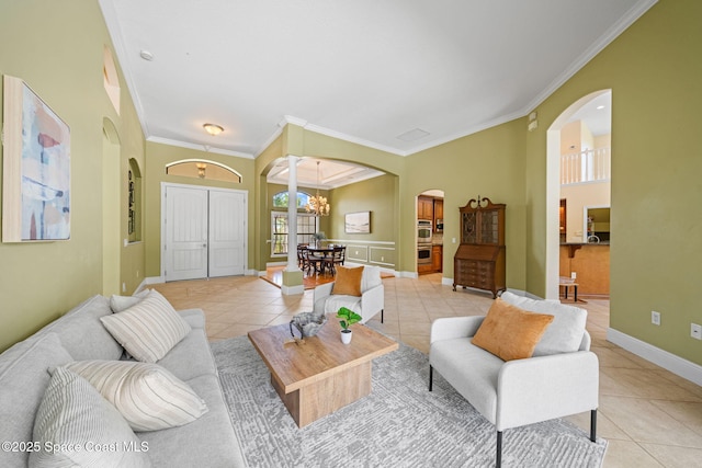 living room with arched walkways, light tile patterned floors, ornamental molding, and a notable chandelier
