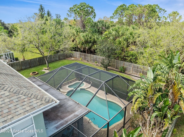 view of swimming pool with a fenced in pool, glass enclosure, a fenced backyard, an in ground hot tub, and a yard