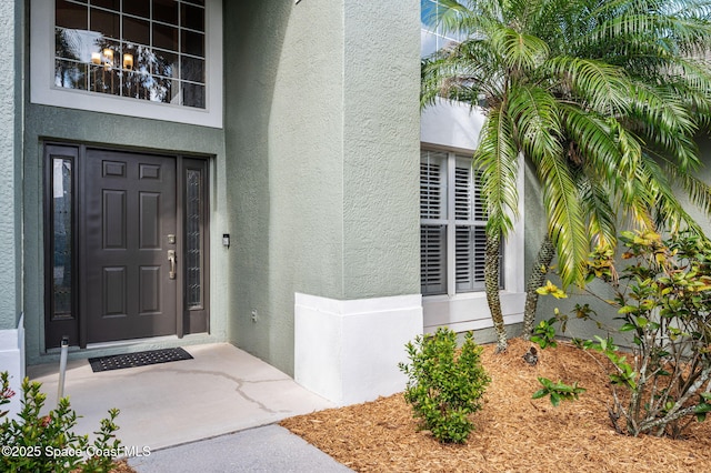 entrance to property featuring stucco siding