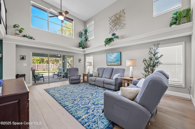 living area with ceiling fan, baseboards, and wood finished floors