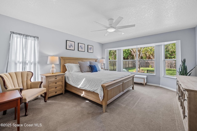 carpeted bedroom featuring ceiling fan, baseboards, and a textured ceiling