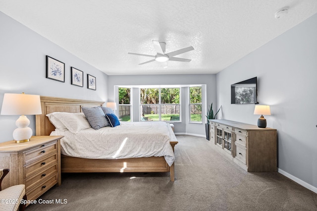 bedroom featuring a textured ceiling, carpet, and baseboards