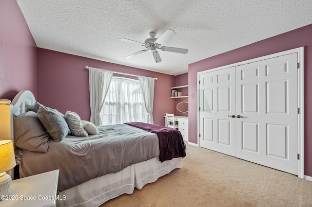 carpeted bedroom featuring baseboards, a textured ceiling, a ceiling fan, and a closet