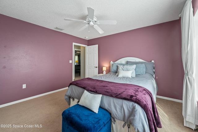 carpeted bedroom featuring baseboards, visible vents, ceiling fan, and a textured ceiling