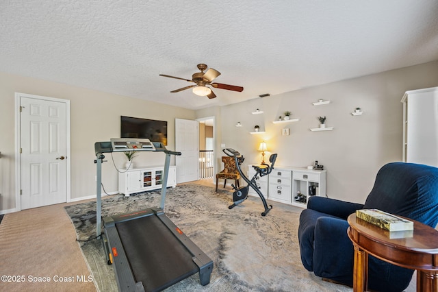 workout room with carpet floors, baseboards, a ceiling fan, and a textured ceiling