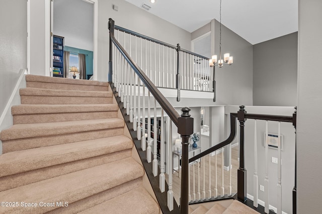 staircase with a chandelier, visible vents, and baseboards