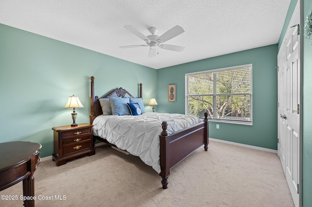 carpeted bedroom featuring a textured ceiling, a closet, a ceiling fan, and baseboards