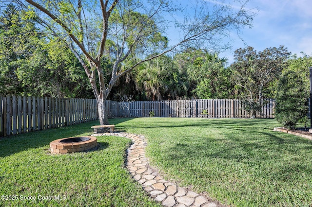 view of yard featuring a fire pit and a fenced backyard