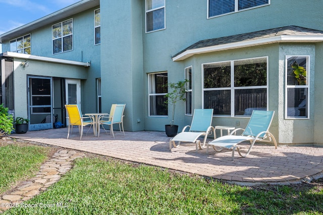 back of property featuring a patio area and stucco siding